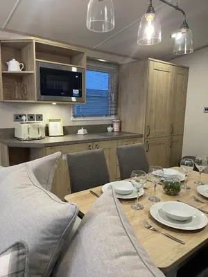 a dining room with a table with plates and wine glasses at 3 BR - Luxury Family Home Near The Beach in East Mersea