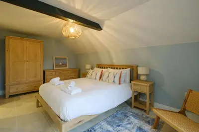 a bedroom with a bed with two towels on it at Boat Shelter Cottage in Thorpeness