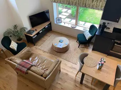 a living room with a couch and a table at Private Apartment at Woodland Retreat in Gamlingay