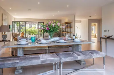 a dining room with a table and benches at Luxurious resort house near beach - Mallards in Thorpeness
