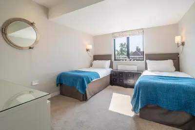 a small bedroom with two beds and a mirror at Luxurious resort house near beach - Mallards in Thorpeness