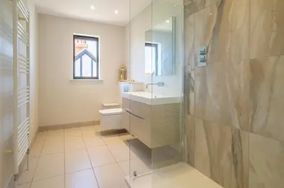 a bathroom with a shower and a toilet and a sink at Luxurious resort house near beach - Mallards in Thorpeness
