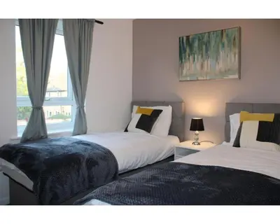 two beds in a bedroom with a window at A Comfortable Nest for Contractors or Families - sleeps 8 in Chesterton