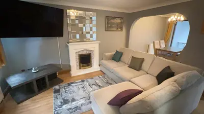 a living room with a couch and a fireplace at Cosy 4 bedroom holiday let Stevenage 22mins from London on the train in Stevenage