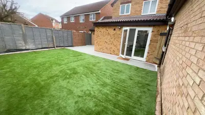 a backyard with a green lawn next to a house at Cosy 4 bedroom holiday let Stevenage 22mins from London on the train in Stevenage