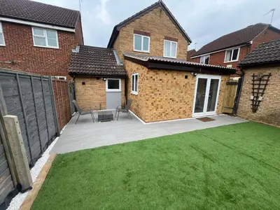 a backyard of a house with a lawn at Cosy 4 bedroom holiday let Stevenage 22mins from London on the train in Stevenage
