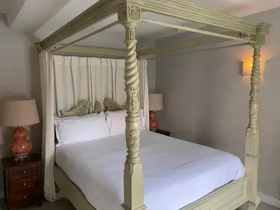 a bedroom with a white bed with a canopy at The Bull Inn in Woodbridge
