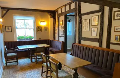 a restaurant with tables and chairs and a window at The Bull Inn in Woodbridge