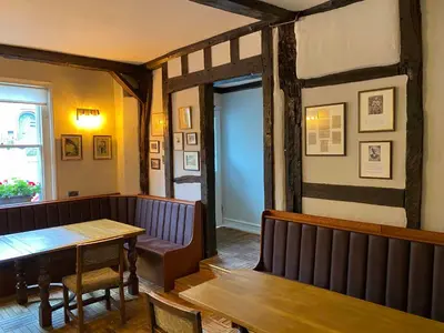 a dining room with a table and a bench at The Bull Inn in Woodbridge