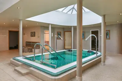 a large bathroom with a hot tub in a house at Ufford Park Resort in Woodbridge