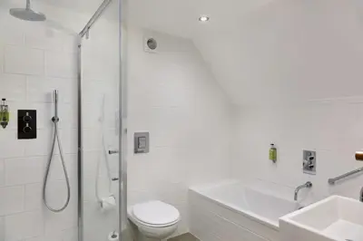 a bathroom with a shower and a toilet and a sink at Ufford Park Resort in Woodbridge