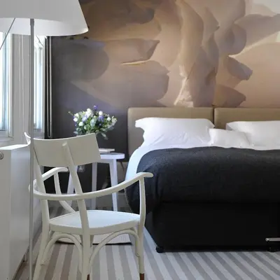 a bedroom with a bed and a chair and a table at The Crown Hotel in Woodbridge