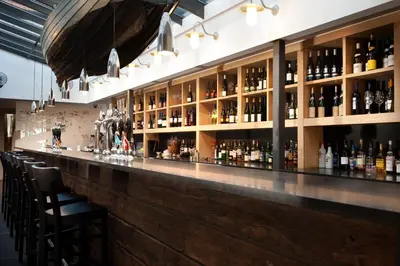 a bar with a lot of bottles of alcohol at The Crown Hotel in Woodbridge