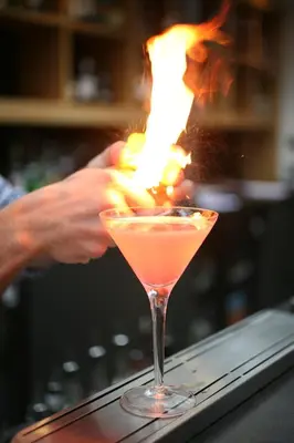 a person is making a cocktail in a bar at The Crown Hotel in Woodbridge