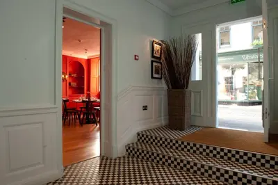 a hallway with a doorway with a vase with a plant at The Crown Hotel in Woodbridge