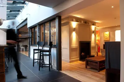 a living room with a bar and a fireplace at The Crown Hotel in Woodbridge