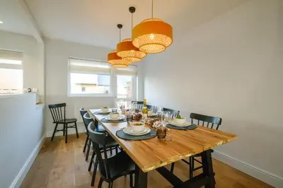 a dining room with a wooden table and chairs at Coastguards in Aldeburgh