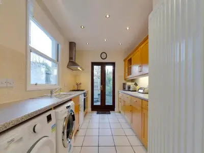 a kitchen with a sink and a washing machine at Pass the Keys Modern and Spacious Terrace in Central Cambridge in Cambridge