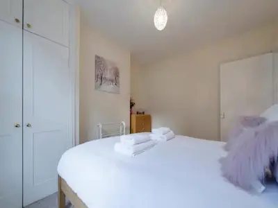 a bedroom with a white bed with towels on it at Pass the Keys Modern and Spacious Terrace in Central Cambridge in Cambridge