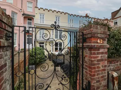a black iron gate with a building behind it at 42 Crag Path in Aldeburgh