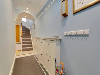 a kitchen with white cabinets and a staircase at Pass the Keys Centrally located modern and spacious 3 Bed terrace in Cambridge