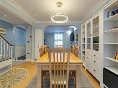 a dining room with a wooden table and chairs at Pass the Keys Centrally located modern and spacious 3 Bed terrace in Cambridge