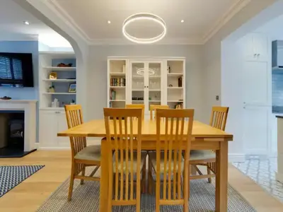 a dining room with a wooden table and chairs at Pass the Keys Centrally located modern and spacious 3 Bed terrace in Cambridge