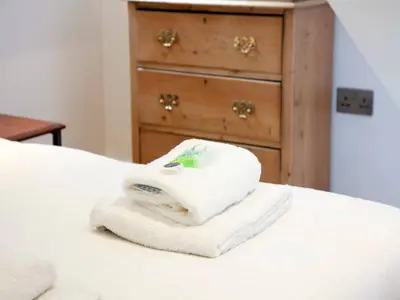 a stack of towels on a bed with a dresser at Pass the Keys Centrally located modern and spacious 3 Bed terrace in Cambridge