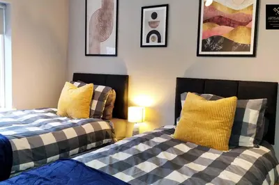 two beds sitting next to each other in a room at The Rose Garden of Basildon in the Heart of Basildon by Artisan Stays I Weekly or Monthly Stay Offer I Pvt Parking I Sleeps 6 in Basildon