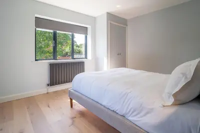 a white bedroom with a large bed and a window at Court House, Aldeburgh in Aldeburgh