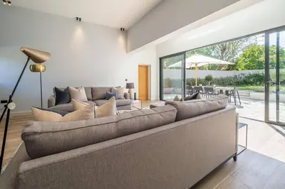 a living room with a large couch and a patio at Court House, Aldeburgh in Aldeburgh