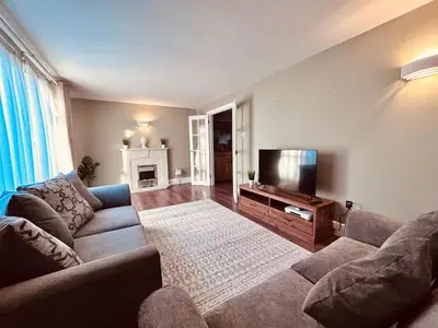 a living room with a couch and a flat screen tv at Stunning 3BR House w/ Parking in Stevenage