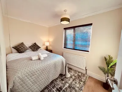 a bedroom with a bed and a window at Stunning 3BR House w/ Parking in Stevenage