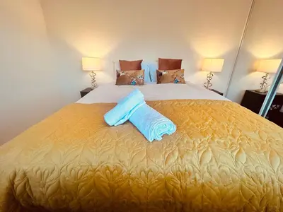a large bed with two blue pillows on it at Stunning 3BR House w/ Parking in Stevenage