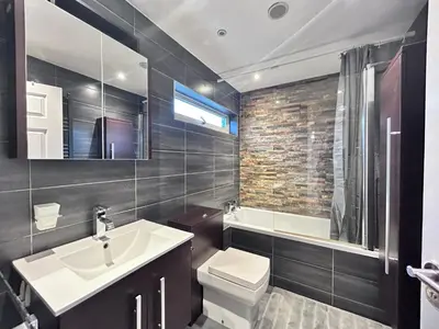 a bathroom with a sink and a toilet and a tub at Stunning 3BR House w/ Parking in Stevenage