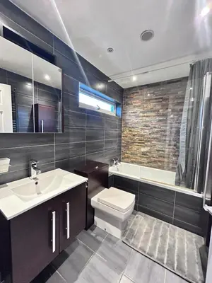 a bathroom with a sink and a toilet and a tub at Stunning 3BR House w/ Parking in Stevenage