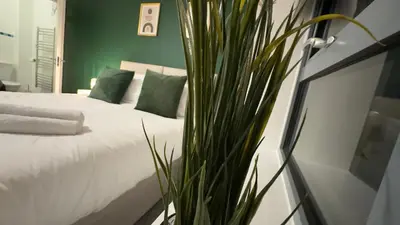 a bedroom with a bed with green walls and a plant at Long Stay - Free Parking - Contractors - Train Station - Students in Colchester
