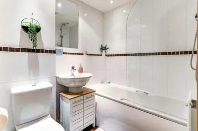 a bathroom with a sink and a toilet and a bath tub at Entire 2 Bed Flat Contractors Families and Relocators in Ware