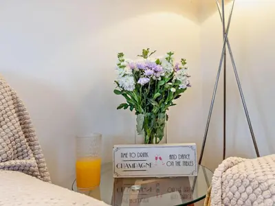 a vase of flowers sitting on a table with a sign at 2 Bed in Norwich oc-73624 in East Harling