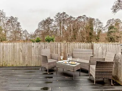 a patio with chairs and a table with wine glasses at 2 Bed in Norwich oc-73624 in East Harling
