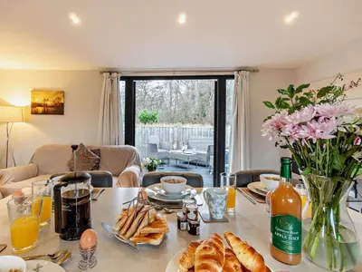 a table with bread and flowers on it in a living room at 2 Bed in Norwich oc-73624 in East Harling