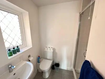 a bathroom with a toilet and a sink and a window at Modern 3 bed House with two bathrooms! Free parking! in Bar Hill