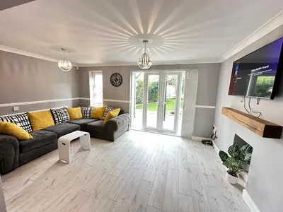 a living room with a couch and a tv at Modern 3 bed House with two bathrooms! Free parking! in Bar Hill