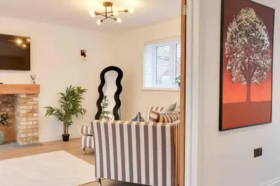 a living room with a table and a chair at Kestrel Gardens Dunmow in Great Dunmow