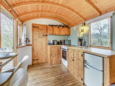 a kitchen with wooden cabinets and a large window at 1 Bed in Norwich oc-57900 in East Harling