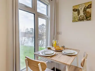 a dining room with a table and a large window at 1 Bed in Norwich oc-76493 in East Harling