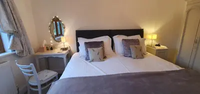 a bedroom with a bed with white sheets and pillows at The Granary Stradbroke in Fressingfield