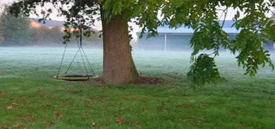 a tire swing hanging from a tree in a field at The Granary Stradbroke in Fressingfield