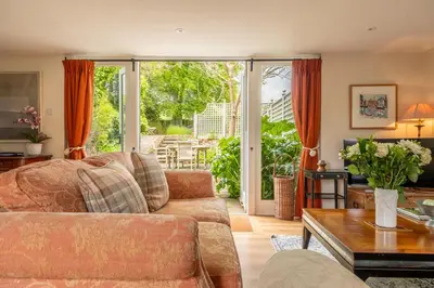 a living room with a couch and a table at Dedham Vale Cottage with Swimming Pool mid May to mid Sep - Yew Tree Barn in Higham