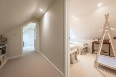 a room with a ladder next to a bedroom at Dedham Vale Cottage with Swimming Pool mid May to mid Sep - Yew Tree Barn in Higham